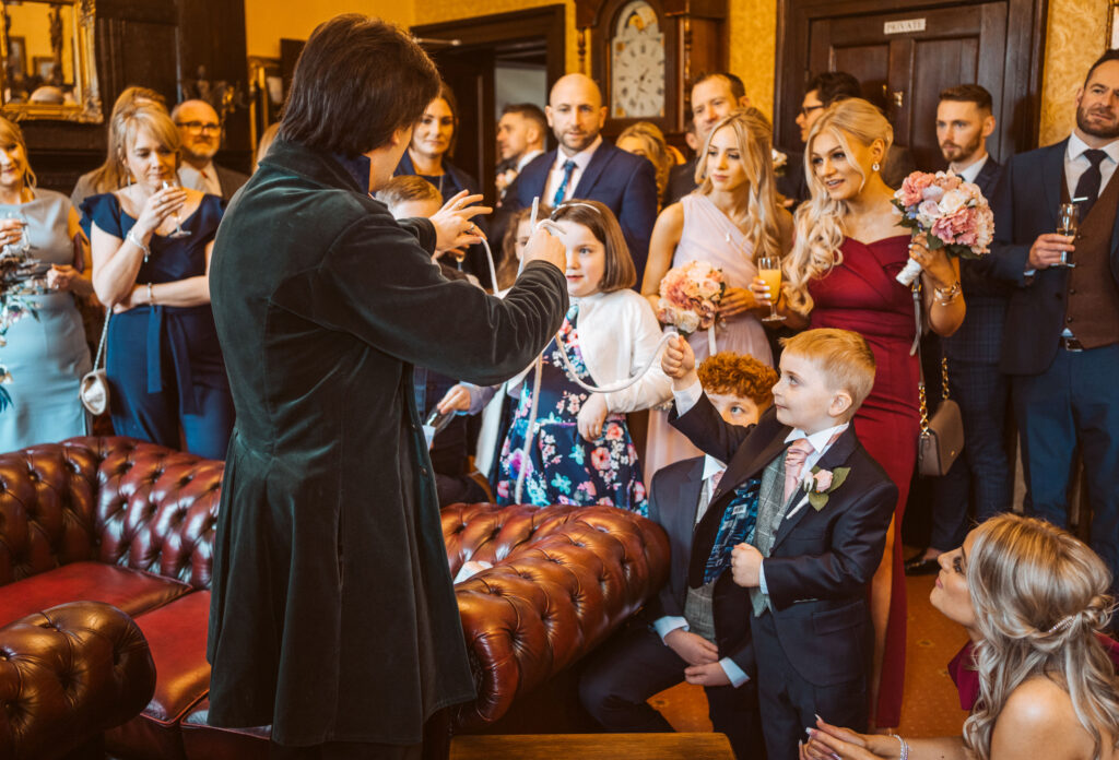 Jay Gatling performing a parlour show to a room of wedding guests.